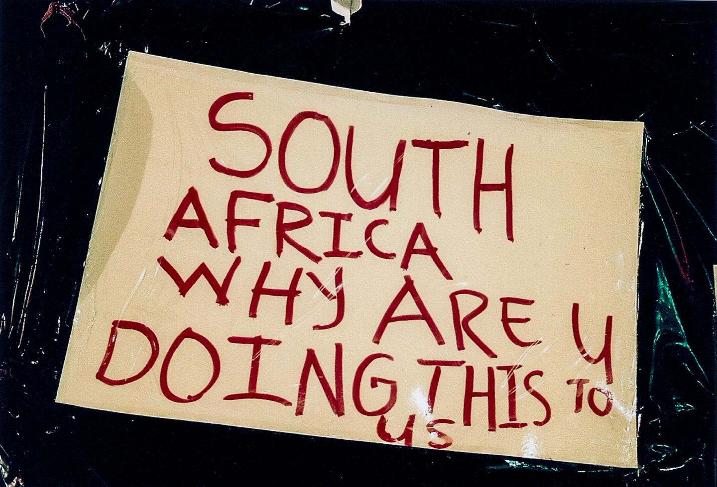 Sign made by victims of xenophobia and worried African expats outside the Cape Town central police station, 2018.